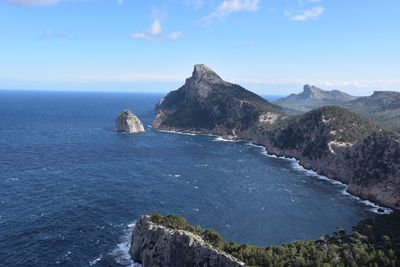 Scenic view of sea by cliff against sky