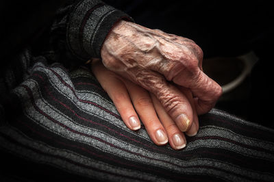 Midsection of granddaughter and grandmother holding hands