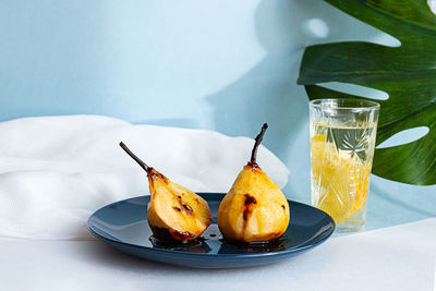 Summer still life pears baked in caramel syrup, lemonad and monstera palm leaf. healthy food concept