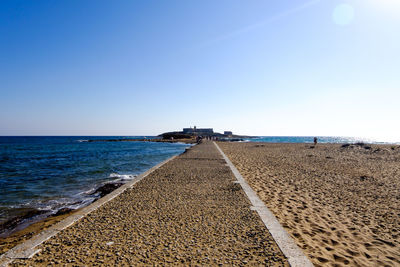 Scenic view of beach against clear blue sky