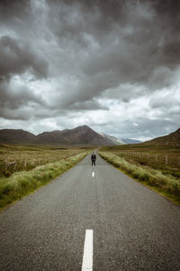 Rear view of man on road against sky