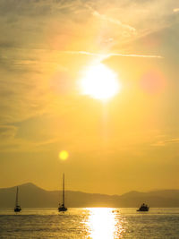 Silhouette of boats in sea during sunset