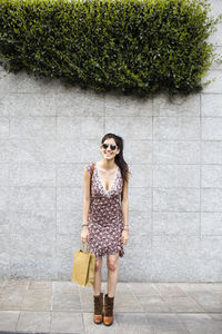 Happy young woman holding shopping bag