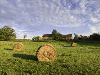 Hay bales on field against sky