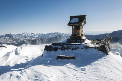 Built structure on snow covered mountain against sky