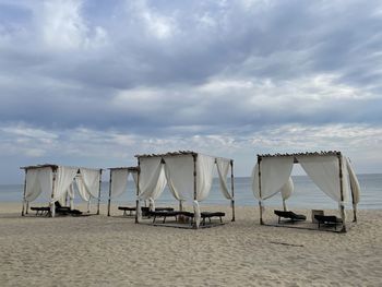 Chairs on beach against sky