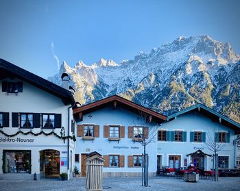 Houses against snowcapped mountains against clear sky