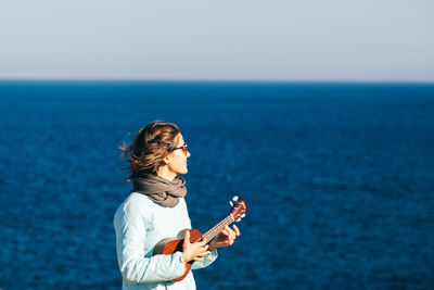 Woman standing on beach against clear sky