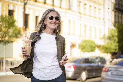 Portrait of young woman standing in city