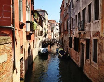 Canal amidst buildings against sky