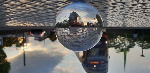 Close-up of crystal ball hanging on glass of building