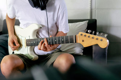 Midsection of woman playing guitar