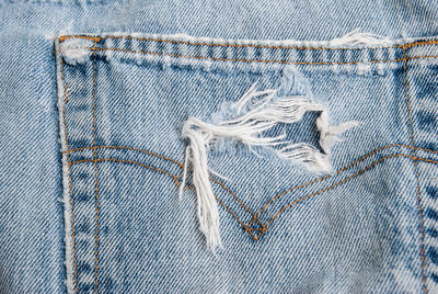 Close-up of torn jeans pocket