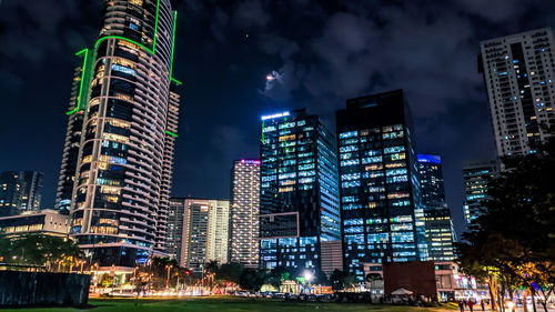 Low angle view of illuminated buildings against sky at night