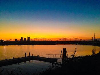 Bridge over river at sunset