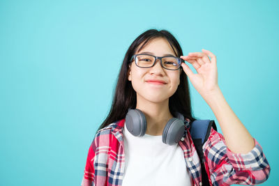 Portrait of a beautiful young woman against blue background