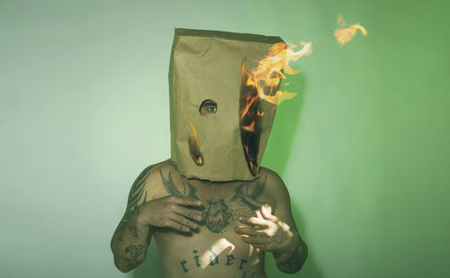 Portrait of a man with a burning paper bag on his head.  surreal image