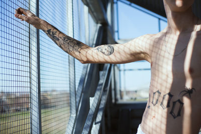 Midsection of man standing by window