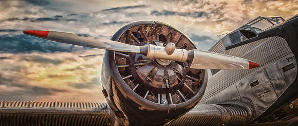 Close-up of airplane against cloudy sky