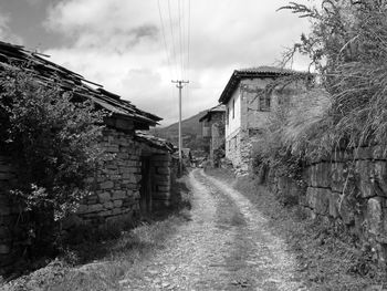 Footpath amidst buildings against sky