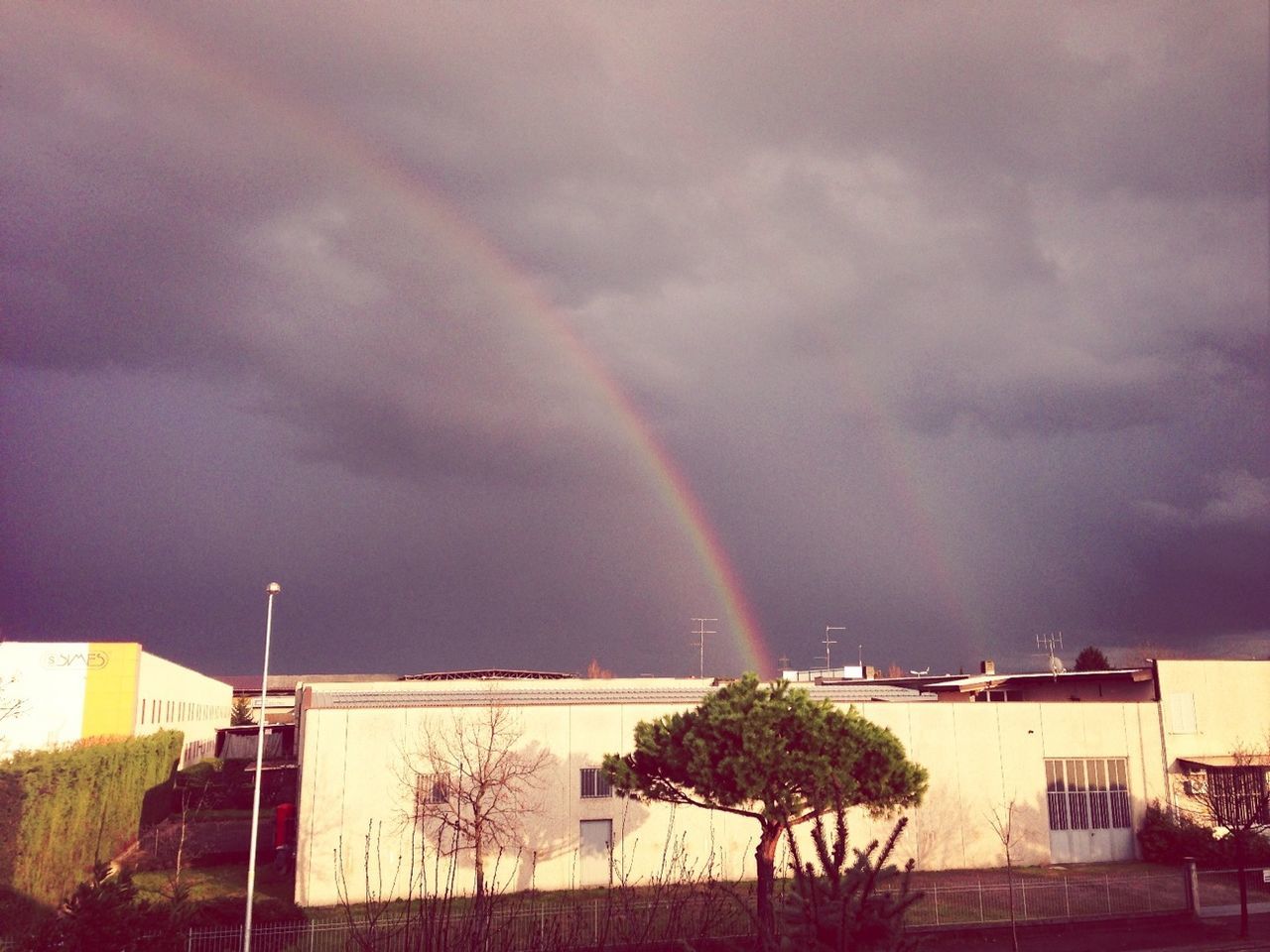 rainbow, building exterior, architecture, built structure, sky, cloud - sky, house, cloudy, weather, multi colored, residential structure, storm cloud, tree, residential building, overcast, nature, outdoors, cloud, beauty in nature, no people