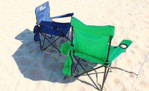 High angle view of empty chair on sand at beach