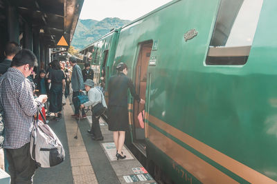 People walking on train in city