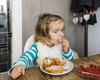 High angle view of cute girl eating food at home