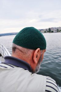 Rear view of man on boat in sea against sky