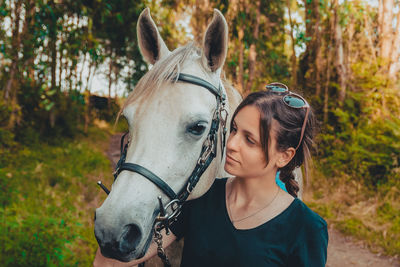 Woman embracing horse on field