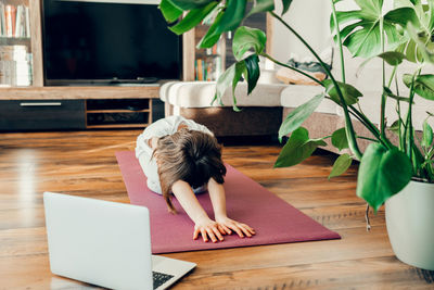 Girl practices yoga at home, doing stretching. children's yoga, sports at home online 