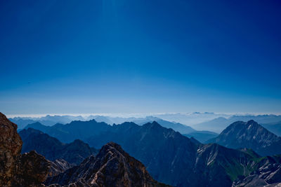 Scenic view of snowcapped mountains against blue sky