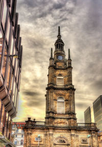 Low angle view of buildings against cloudy sky