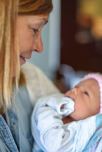 Midsection of mother with baby relaxing at home