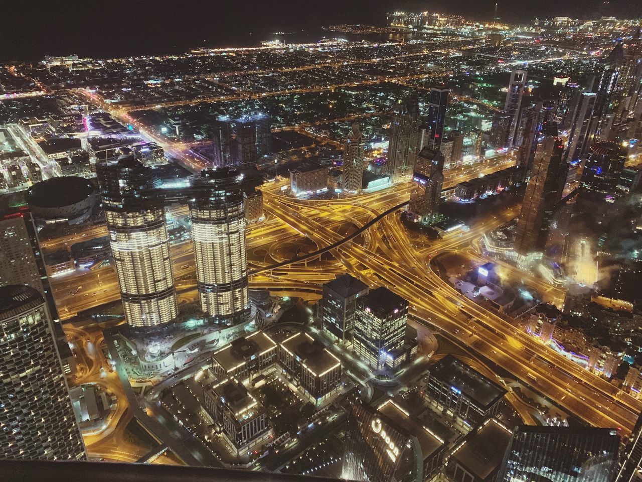 AERIAL VIEW OF ILLUMINATED BUILDINGS IN CITY AT NIGHT