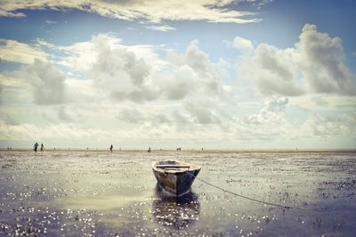 Boat moored on shore at beach against sky at zanzibar