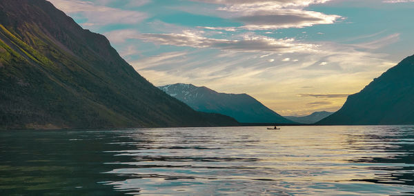 Scenic view of lake by mountains against sky