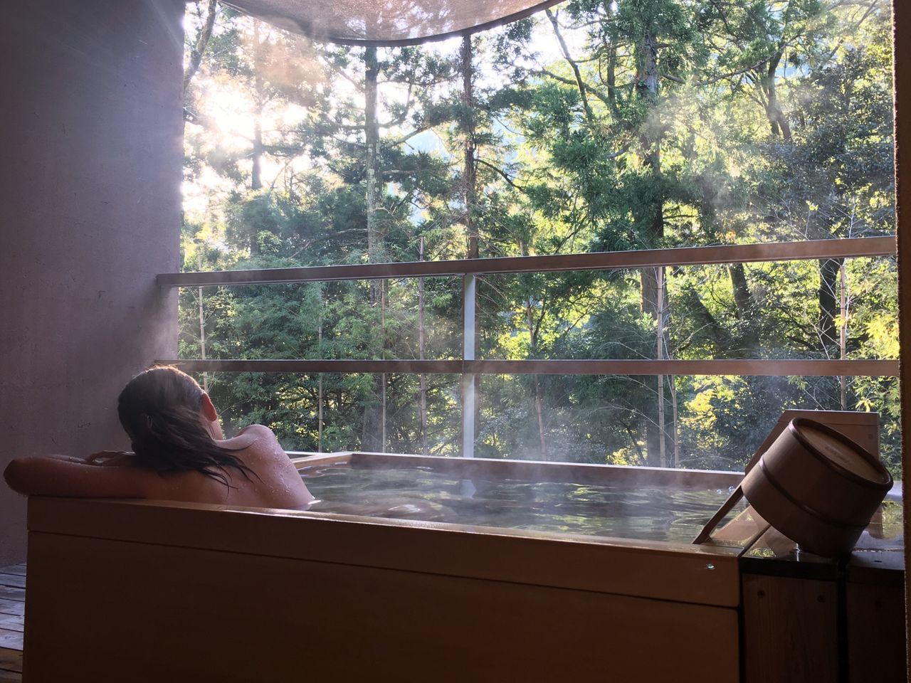 LOW SECTION OF WOMAN RELAXING BY WINDOW IN PARK