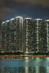 Illuminated buildings against sky at night