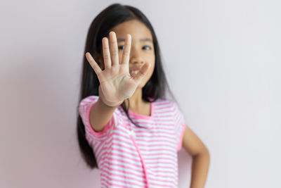 Portrait of woman standing against white background