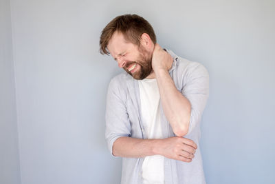 Young man looking away against white background