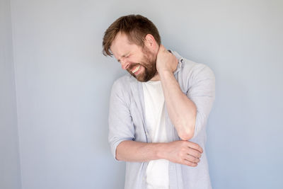 Young man looking away against white background