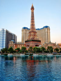 View of buildings by lake against sky