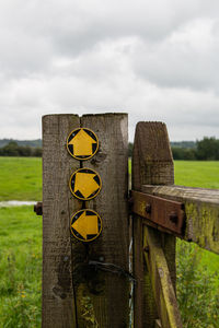 Close-up of wooden fence on field against sky