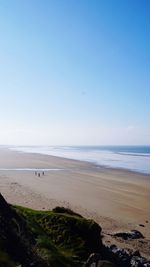 Scenic view of beach against clear blue sky