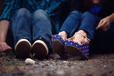 Low section of people sitting on footpath