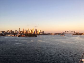 Scenic view of sea by buildings against sky during sunset