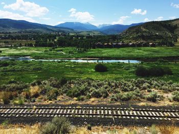 Scenic view of field and mountains against sky