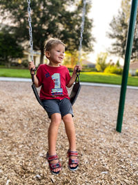 Full length of boy swinging at playground