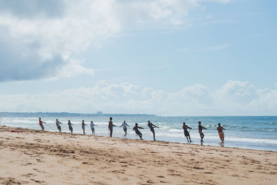 People at beach against sky